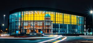 Photograph showing the front of the building lit up at night