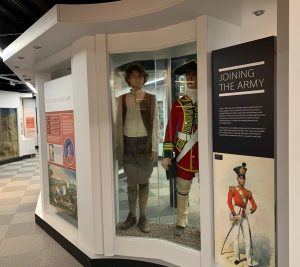 Photograph of museum displays featuring mannequins dressed in historical army clothing