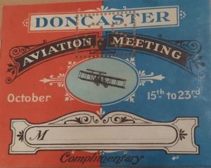 Reads Doncaster Aviation Meeting has a line drawing of a small plane in the centre. the page is coloured red on the left and blue on the right.
