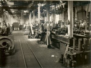 Old black and white photograph of a Plant Work. Showing men and women at work