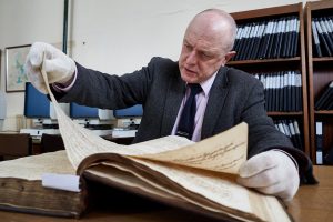 Man looking through historic document.