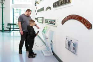 Boy and man looking at the nameplates of trains in the Rail Heritage Centre in the Danum Gallery, Library and Museum